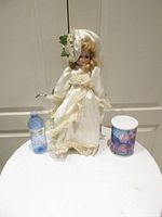 Full view of porcelain doll, puzzle container and water bottle for scale