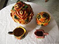 Four ceramic pieces on table, showing colours and forms