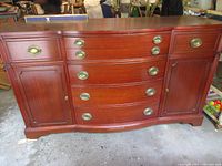 Front view of mahogany dresser showing drawers, doors and hardware