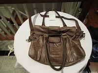 Front view of brown Escada leather purse showing handles, flap, hardware