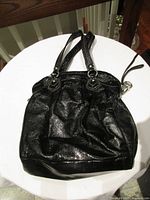 Full view of black Coach Poppy purse