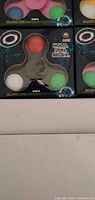 Retail boxes showing Zupa flashing LED fidget spinners
