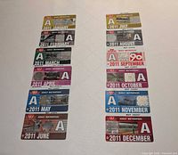 All twelve 2011 TTC Adult Metropass cards laid out in two columns, months clearly visible