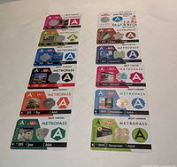 All twelve 2015 TTC Adult Metropass cards laid out in two columns showing fronts and holograms