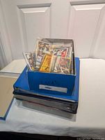 Blue storage box labeled "Cards" atop three binders