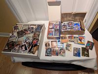 Overview of two long boxes filled with assorted trading cards, additional sleeved cards laid out