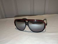 Front view showing frame shape, red trim, lens tint