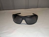Front view of matte black Spy Optic wraparound sunglasses with dark lenses