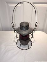 Full view of lantern showing frame, red globe, bail handle