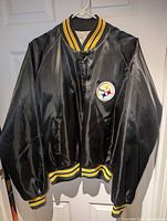 Front view showing logo patch, snap buttons, rib trim, pockets