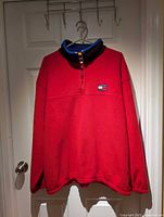 Front view of red quarter-zip fleece showing collar and chest logo