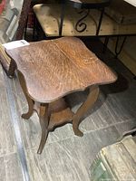 Overall view of solid oak side table showing shape, legs and lower shelf