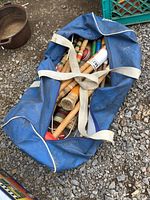Blue duffel bag filled with wooden croquet pieces