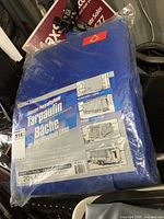 Front of packaged blue polyethylene tarp showing size and material details