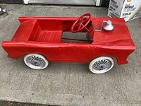 Left front angle showing overall pedal car, steering wheel, bell, wheels