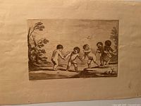 Full view of etching mounted on backing showing five dancing putti