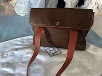 Front view of tote resting on branded dust bag