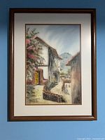Full view of framed watercolor painting on blue wall