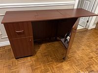 Cabinet closed on left side, right door open showing thread rack and casters