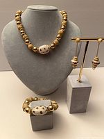 Full view of necklace on bust, bracelet and earrings on stands