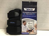 Front of boxed Tismod thumb & wrist support brace with brace displayed