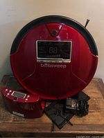 Front view of red Bobsweep robotic vacuum showing display