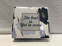 Closed decorative box front, floral design, text "The best is yet to come"