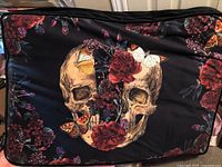 Front view of dog bed showing skull, roses and butterflies print