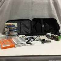 All items grouped: carrying case, DVD spindles, mini DV tapes, AOL CD, phone case, phone mount, floppy drive, microphone, cables