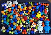 Tray filled with multicolour silicone beads of assorted shapes and animal figures