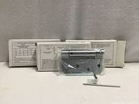 Three boxed spring hinges with one hinge displayed and adjustment tools