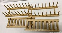 Four bamboo plate racks on surface, showing two peg racks and two slatted racks