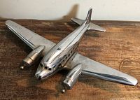 Left front view of chrome DC-3 model showing overall shape and finish