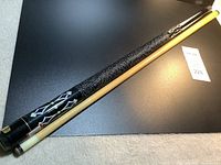 Entire cue assembled showing shaft, wrap and butt