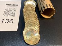 Stack of 1992 Parliament $1 coins emerging from paper roll beside lot card