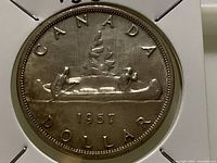 Reverse side of 1957 Canadian silver dollar showing canoe design