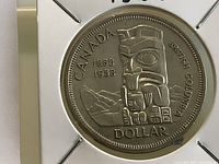 Reverse of 1958 Canadian silver dollar showing totem pole design and inscriptions