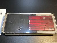 SwissCard Ruby and holster inside clear-lidded tin