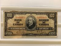 Front of 1937 $100 note showing portrait, serial, signatures, wear