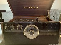 Lid open showing Victrola logo, turntable platter, tonearm, control panel