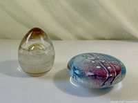 Both glass paperweights side by side