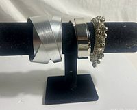 Front view of three bracelets on stand