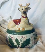 Front view of stoneware cookie jar showing reindeer lid and holly design