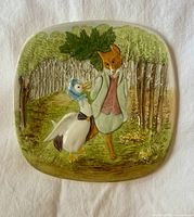 Full view of square ceramic plaque depicting Jemima Puddle-Duck and Mr. Tod on forest path