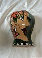 Front view of hand-painted ceramic wall pocket vase with female face design