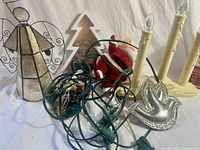 Assorted decorations including angel, tree silhouette, plush Santa, candelabra, flame lights, silver dove