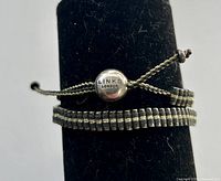 Bracelet on display stand showing round slider clasp engraved Links London and bead rows