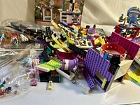 Pile of mixed LEGO Friends and Klutz pieces with bracelet visible