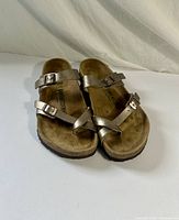 Top view of both sandals showing metallic straps, toe loop, and size