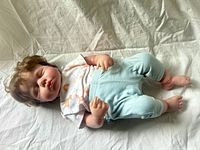 Full view of doll lying on cloth, showing clothing and size proportions